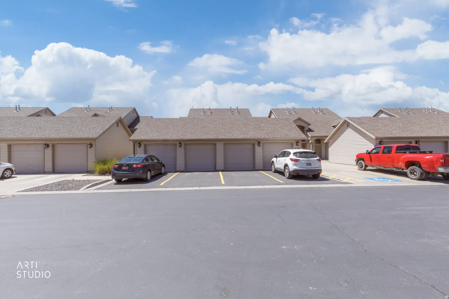 Exterior featuring multiple attached garages with light-toned garage doors