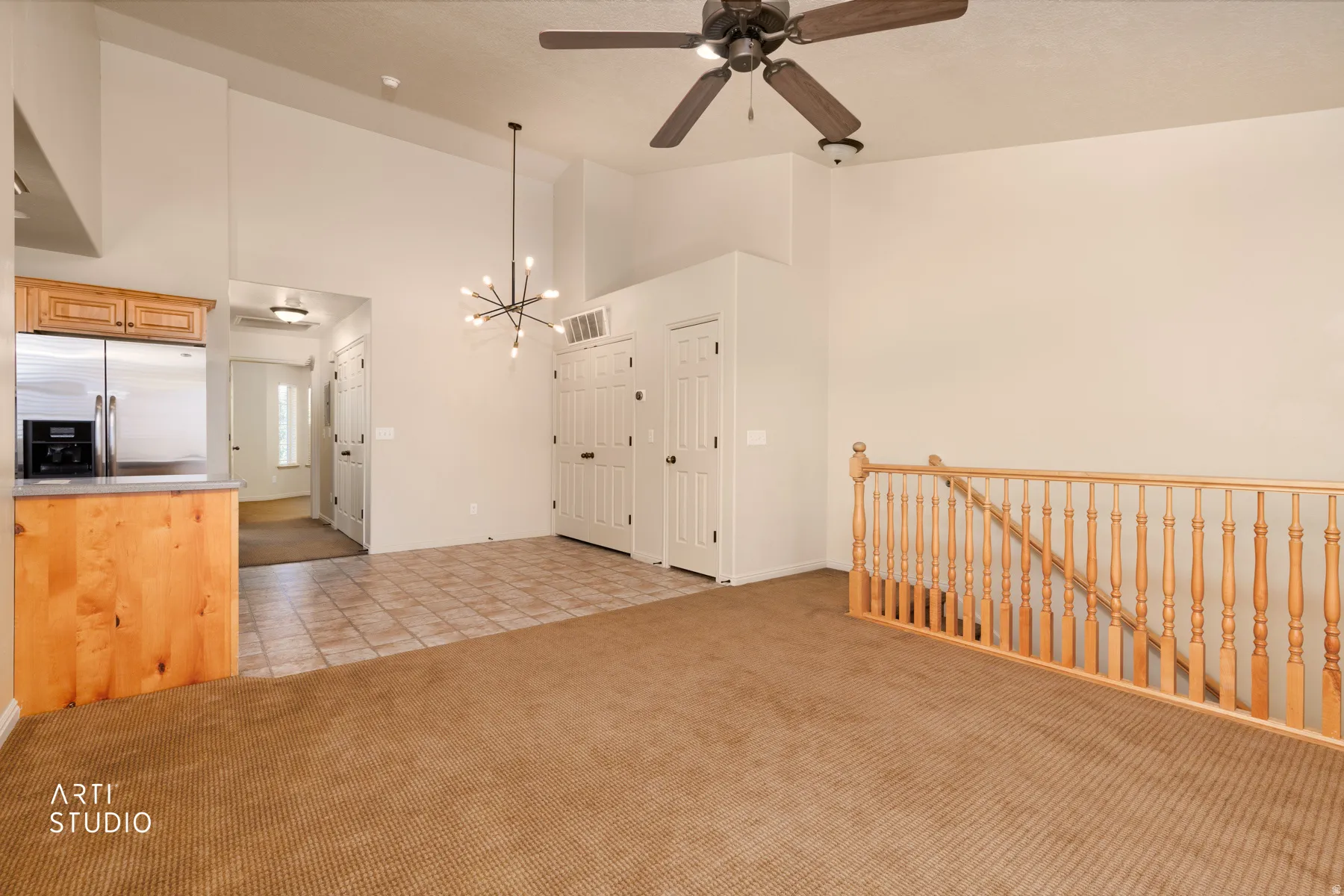 Open-concept living area with vaulted ceilings, a modern sputnik chandelier, and a ceiling fan