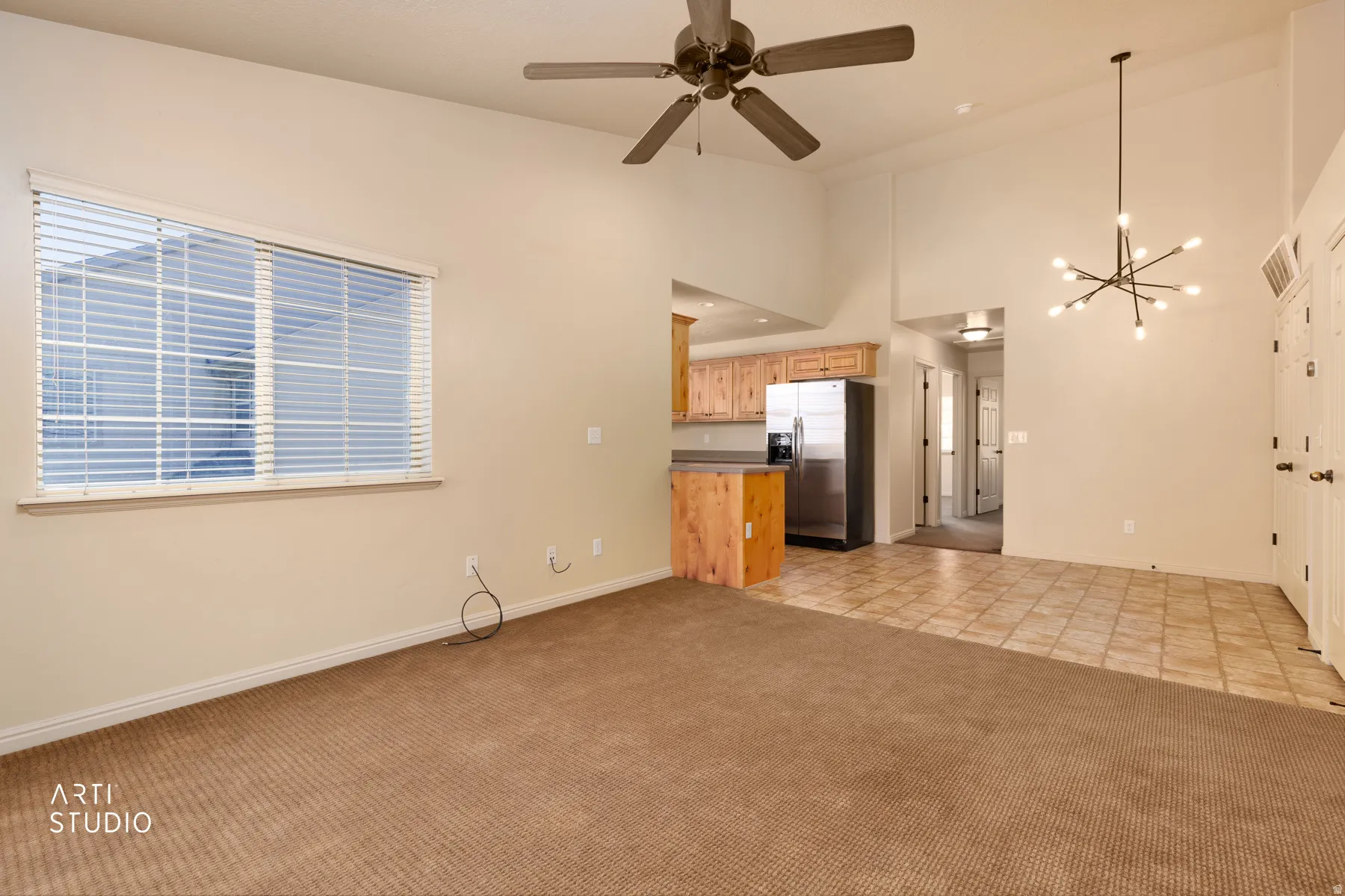 Interior space with vaulted ceilings, featuring a contemporary chandelier and ceiling fan
