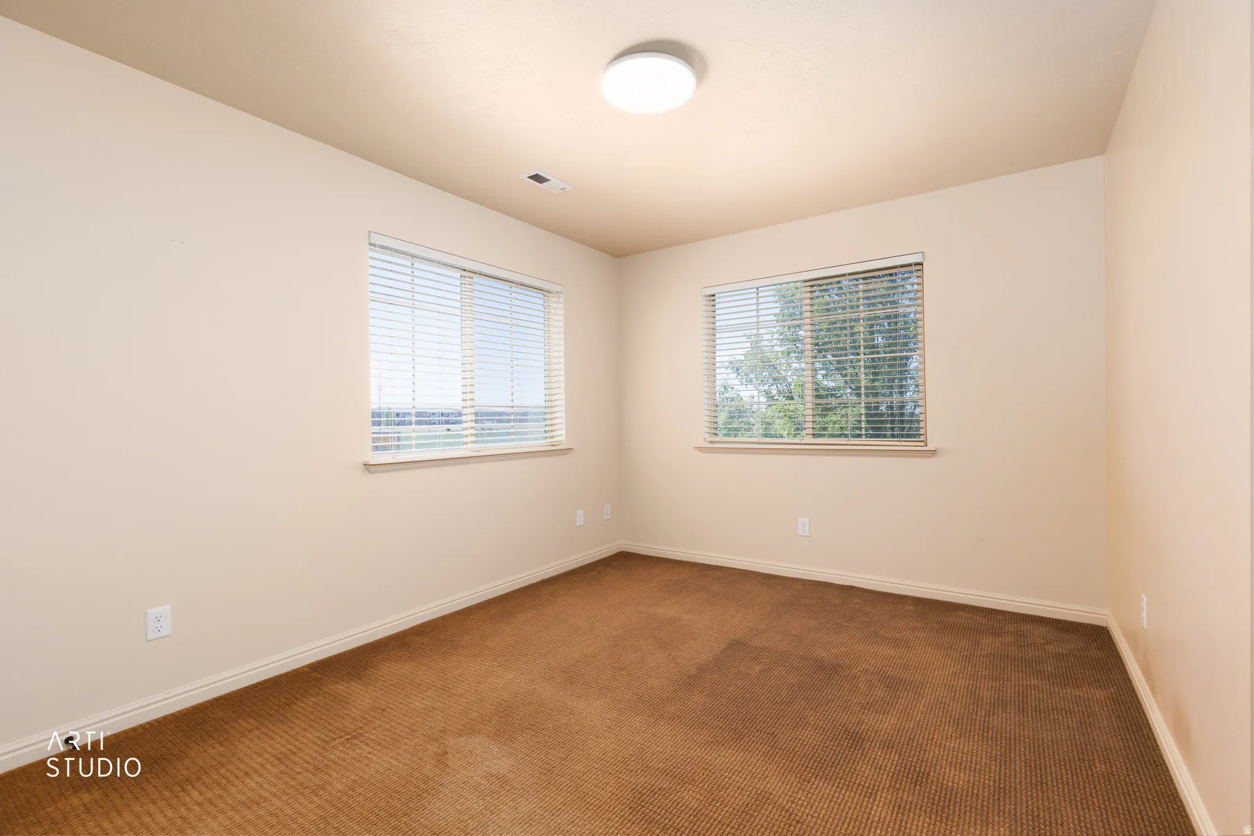 Neutral tone wall paint with two windows featuring horizontal blinds