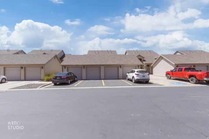 Exterior featuring multiple attached garages with light-toned garage doors