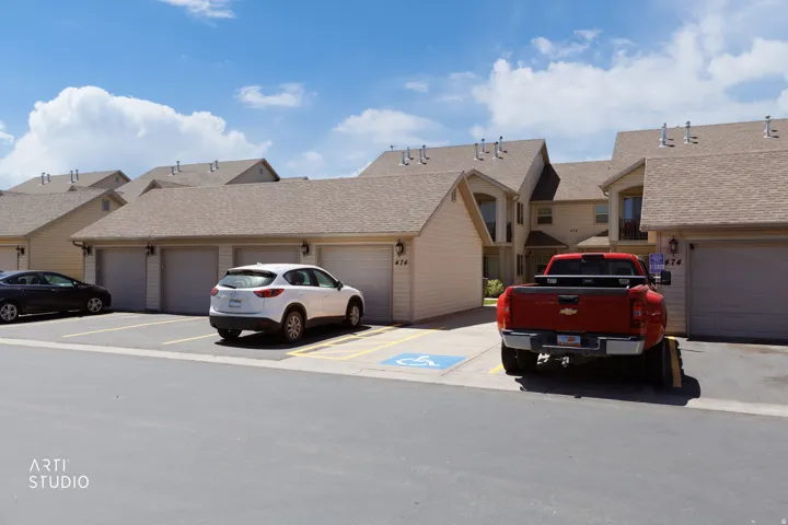 Multi-unit structure featuring light beige siding and individual garage doors