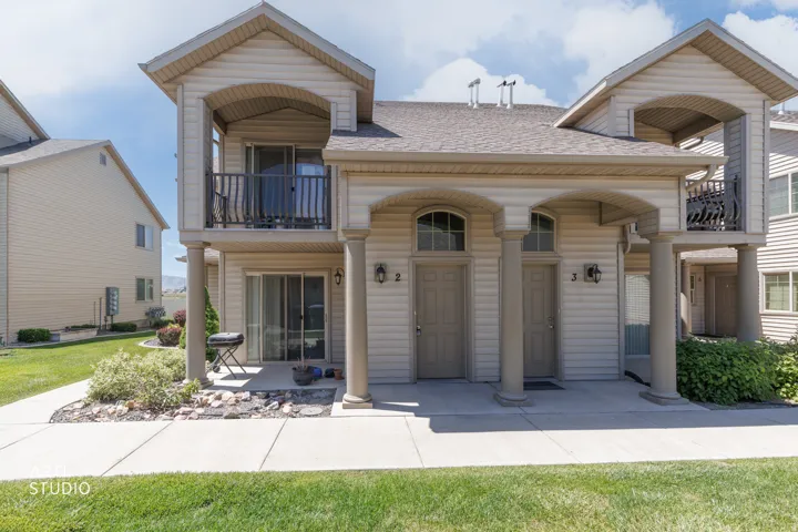 Multi-unit exterior with light-toned siding and a shingle roof