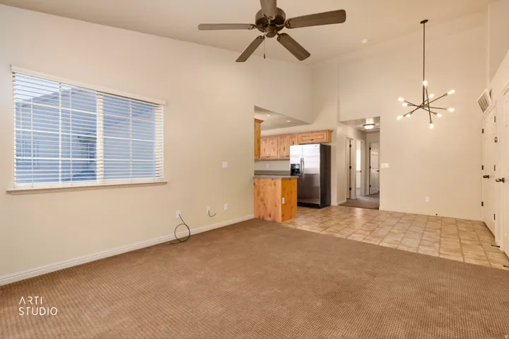 Interior space with vaulted ceilings, featuring a contemporary chandelier and ceiling fan