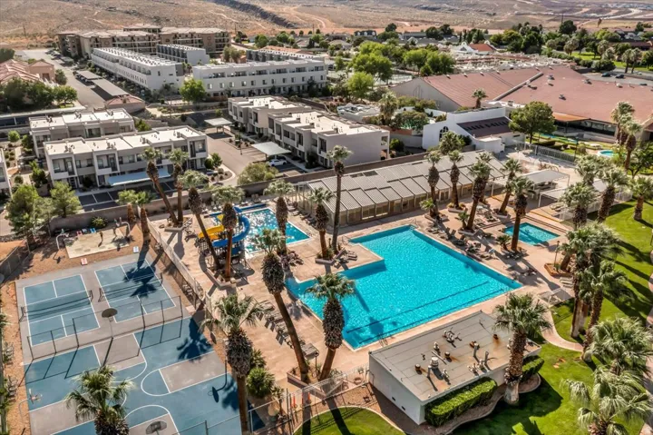 Outdoor amenities featuring multiple swimming pools, a water slide structure, tennis courts, basketball courts, and mature palm trees