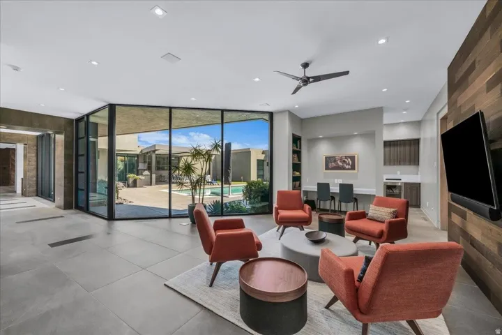 Expansive living area featuring large format tile flooring and floor-to-ceiling glass walls