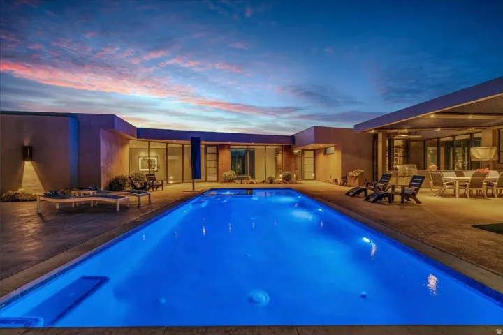 Rectangular swimming pool with integrated spa jets surrounded by concrete decking
