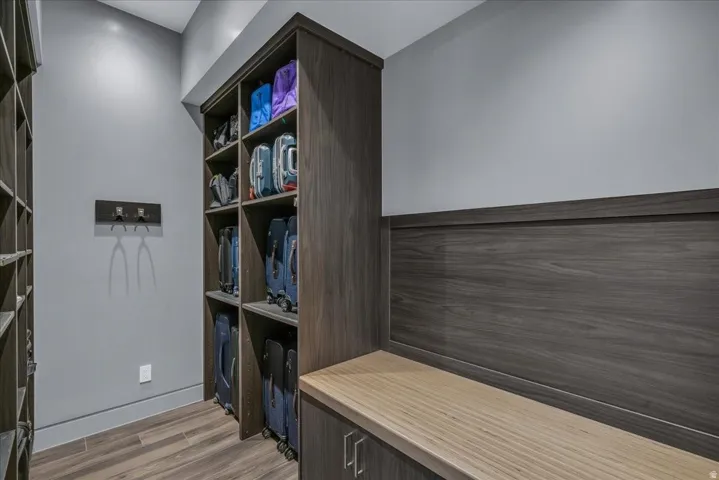 Custom built-in storage system featuring wood-finish cabinetry, open shelving, and a contrasting wood-finish benchtop