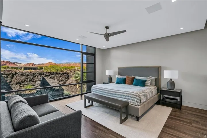 Expansive floor-to-ceiling windows with black framing showcasing desert scenery and distant mountains