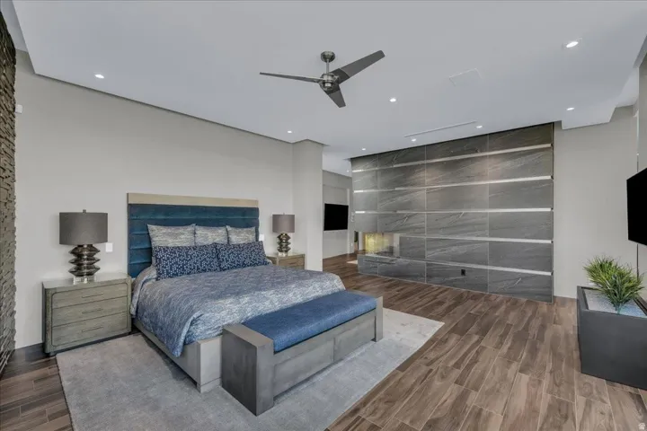 Spacious room featuring wood-finish flooring, a contemporary ceiling fan, and recessed lighting
