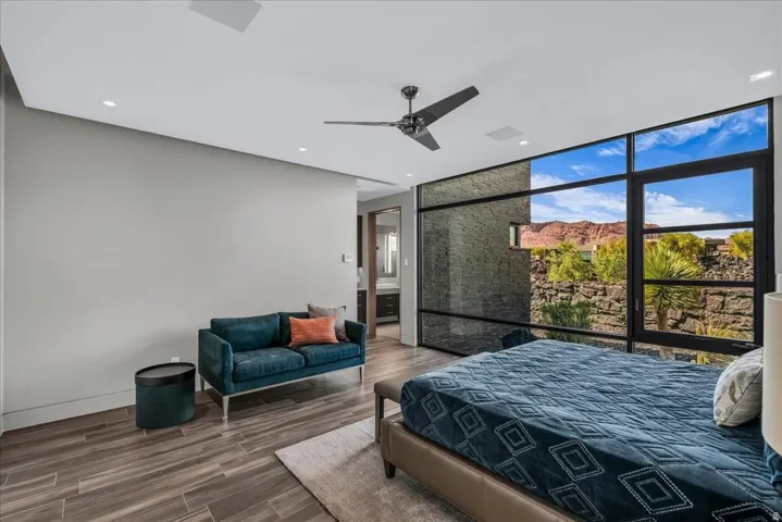 Expansive window wall with black framing, wood-finish flooring, recessed lighting, and ceiling fan