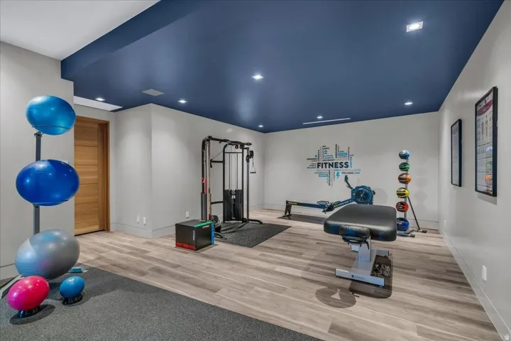 Dedicated fitness room featuring a deep blue accent ceiling with recessed lighting