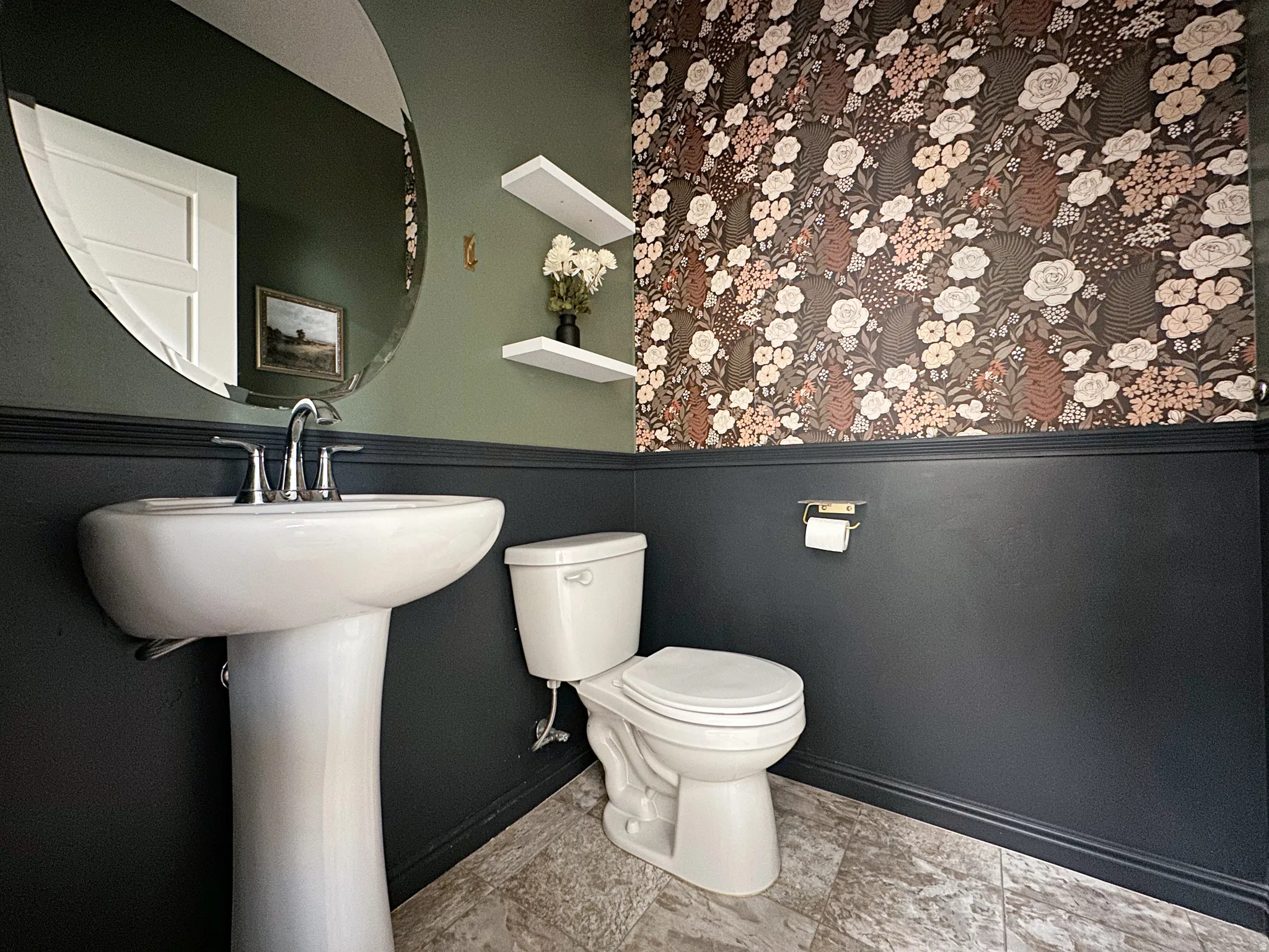 Pedestal sink with chrome fixtures and a large circular mirror