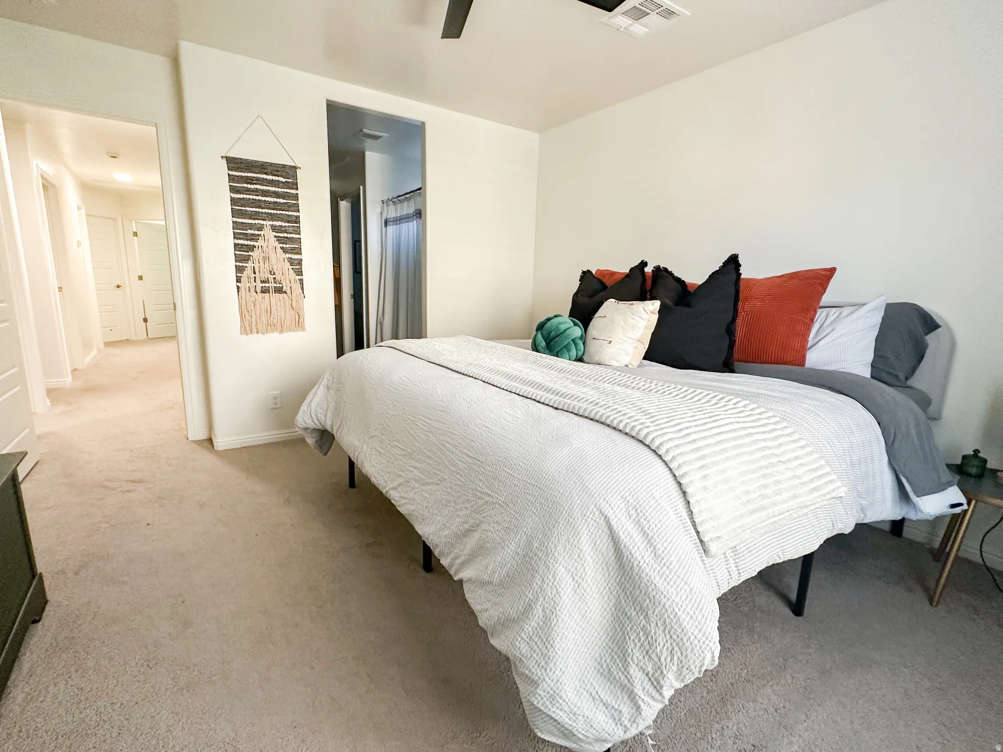 Carpeted bedroom with neutral wall tones and a ceiling fan