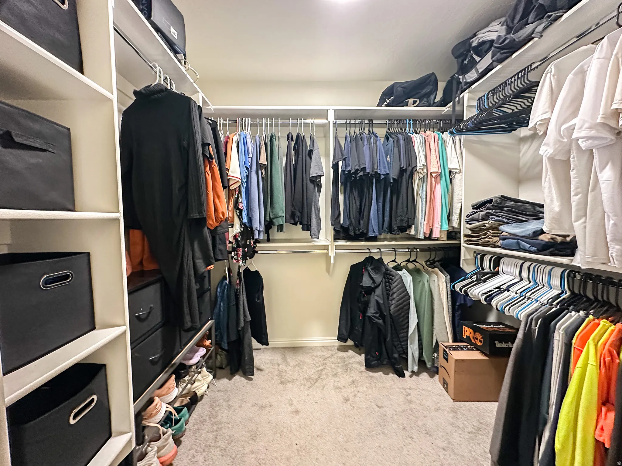 Spacious walk-in closet featuring built-in shelving, multiple hanging rods, and integrated storage options