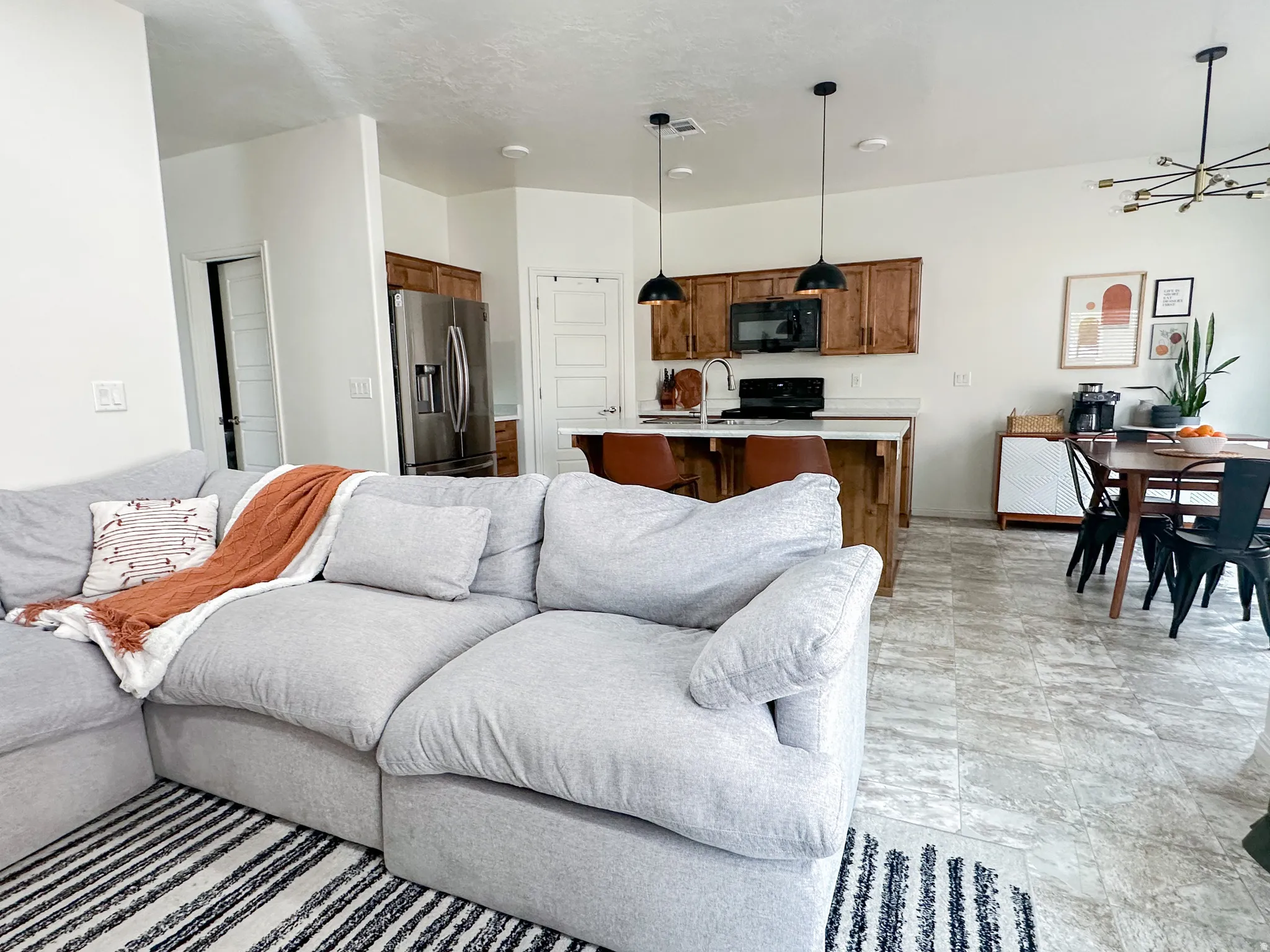 Open-concept living area with light-toned walls and wood-finish cabinetry