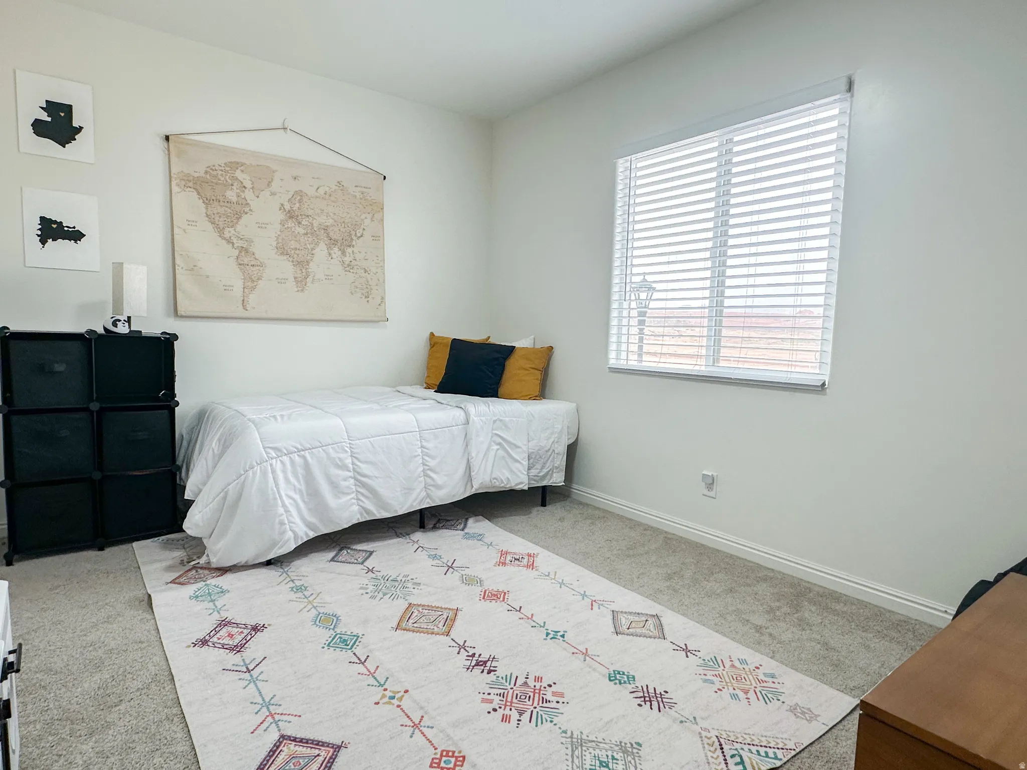 Carpeted room with a single window featuring horizontal blinds