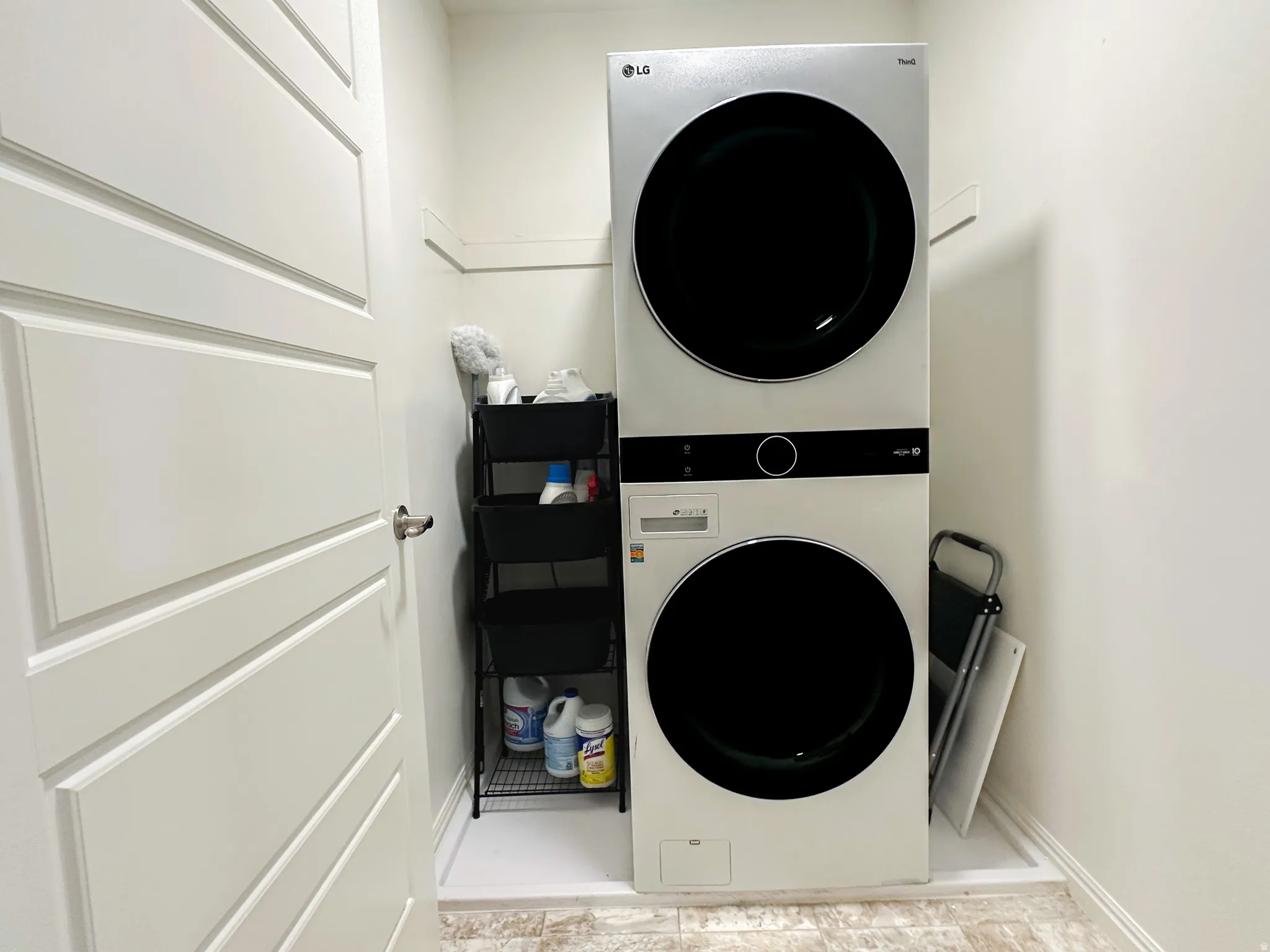 Dedicated laundry area featuring a stacked washer and dryer unit