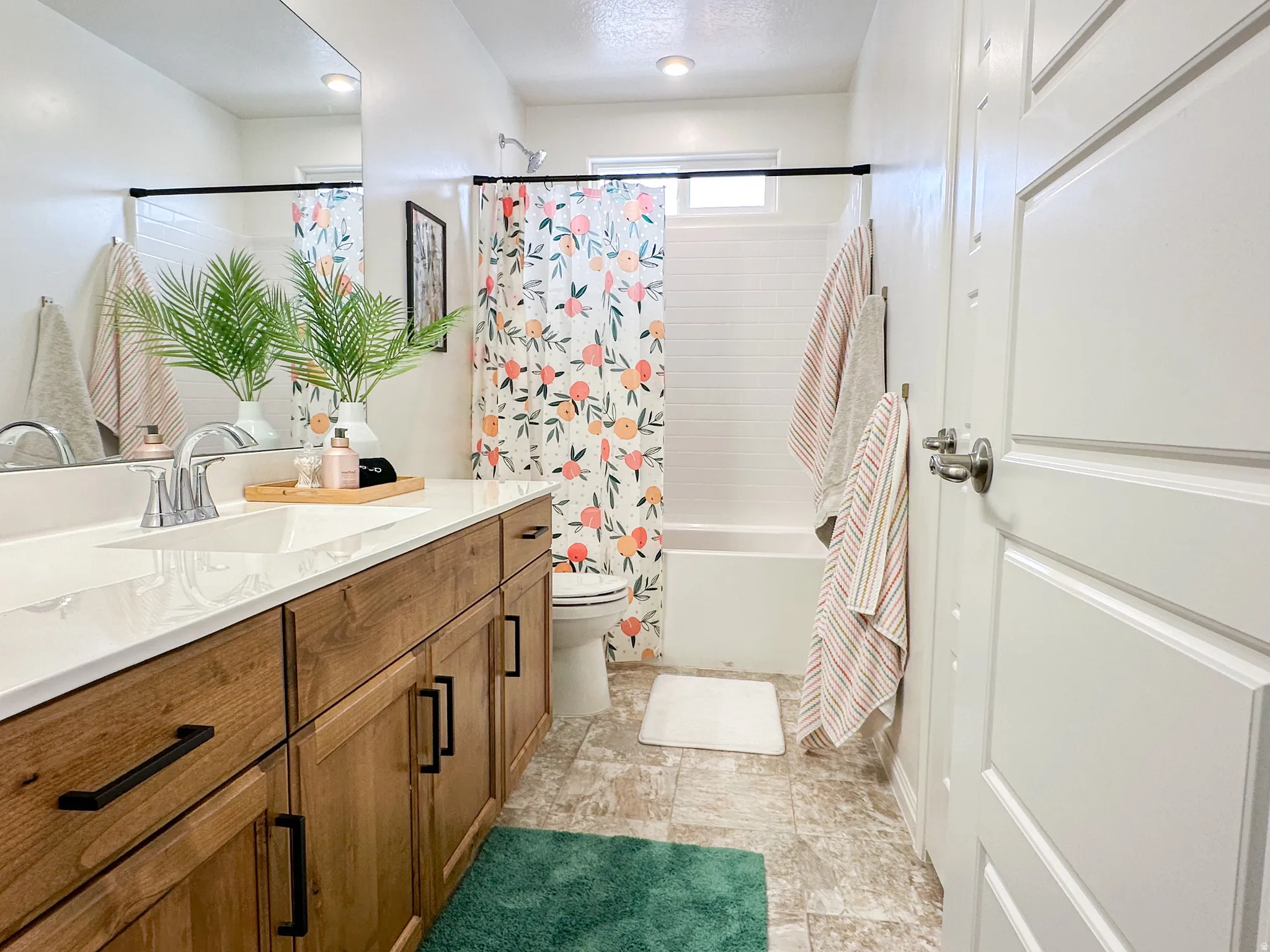 Bathroom featuring a single vanity with wood-finish cabinetry, a white countertop, and a rectangular undermount sink