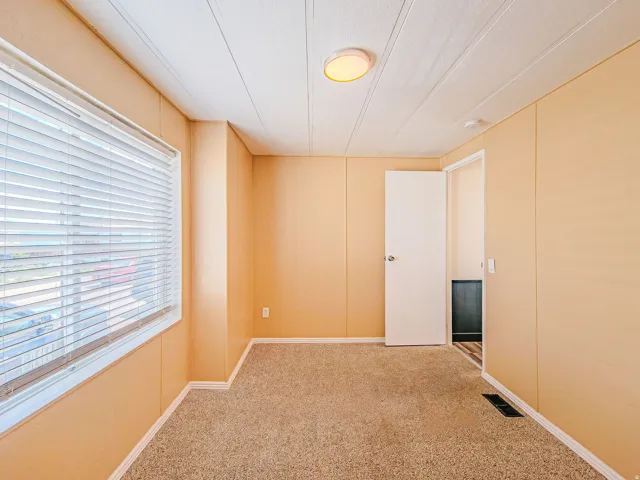 Room featuring textured carpeting and light-colored wall panels