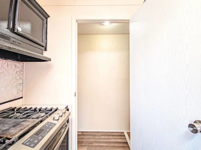 Stainless steel range with griddle, overhead microwave, and decorative backsplash