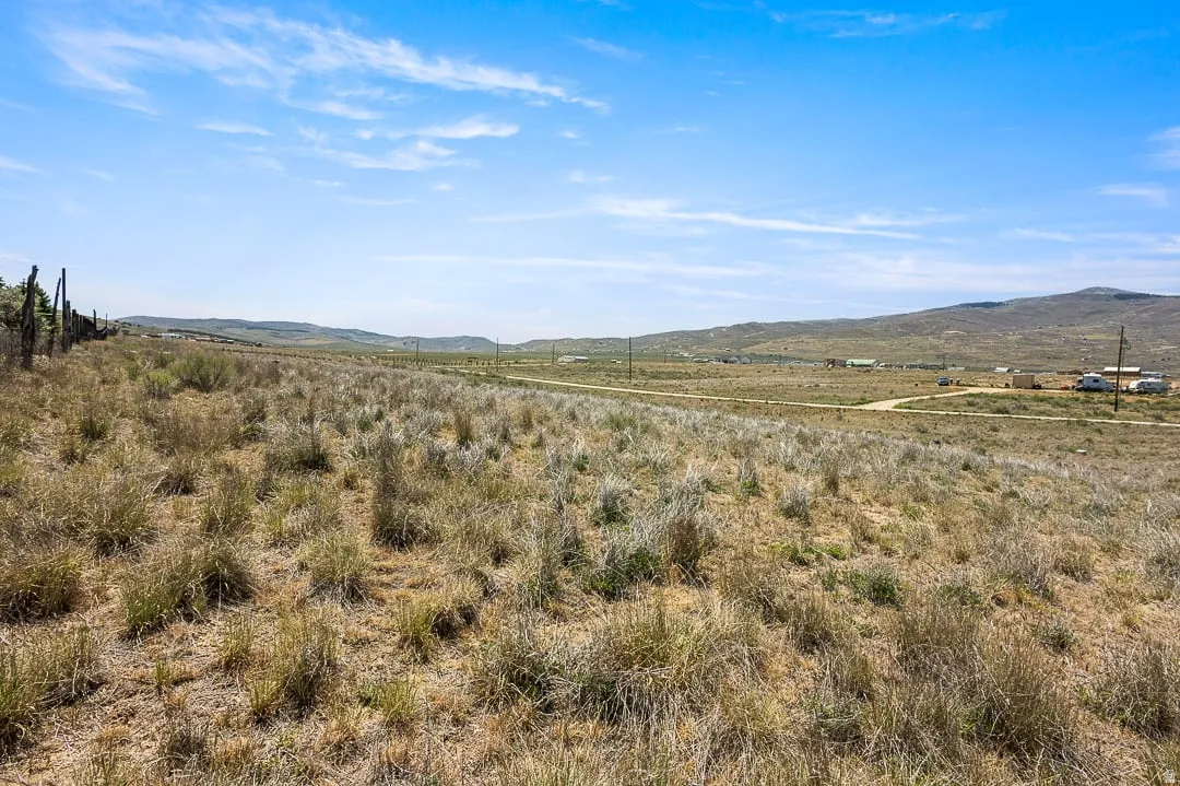 Expansive rural property featuring a distant mountain range and a clear blue sky