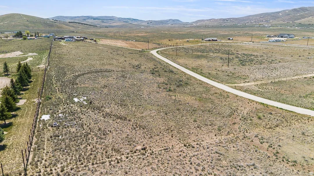 Expansive undeveloped land parcel featuring a paved access road and natural desert landscaping