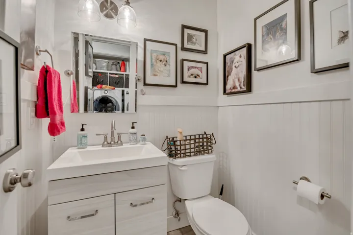 Bathroom featuring a vanity with a rectangular sink, dual-door cabinet, brushed nickel faucet, and a wall-mounted mirror