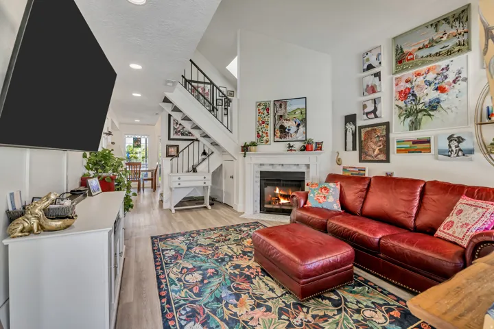 Living area with vaulted ceilings, recessed lighting, and wood-finish flooring