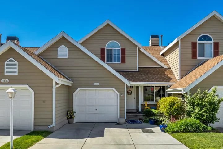 Multi-level facade featuring dormer windows, horizontal siding, and a front entry with an arched transom