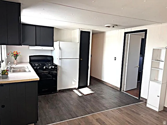 Kitchen featuring wood-finish flooring, dark cabinetry, and light countertops