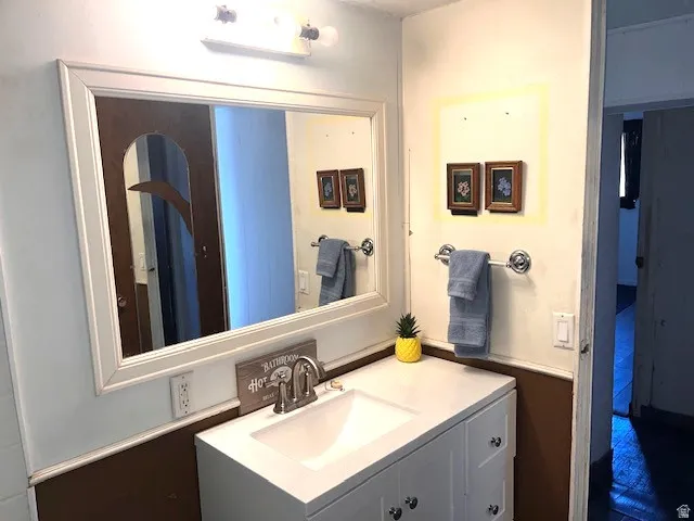 White framed mirror over a single vanity with a white countertop and integrated sink
