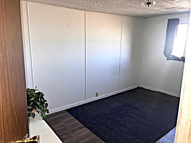 Interior room featuring white paneled walls and a ceiling-mounted light fixture