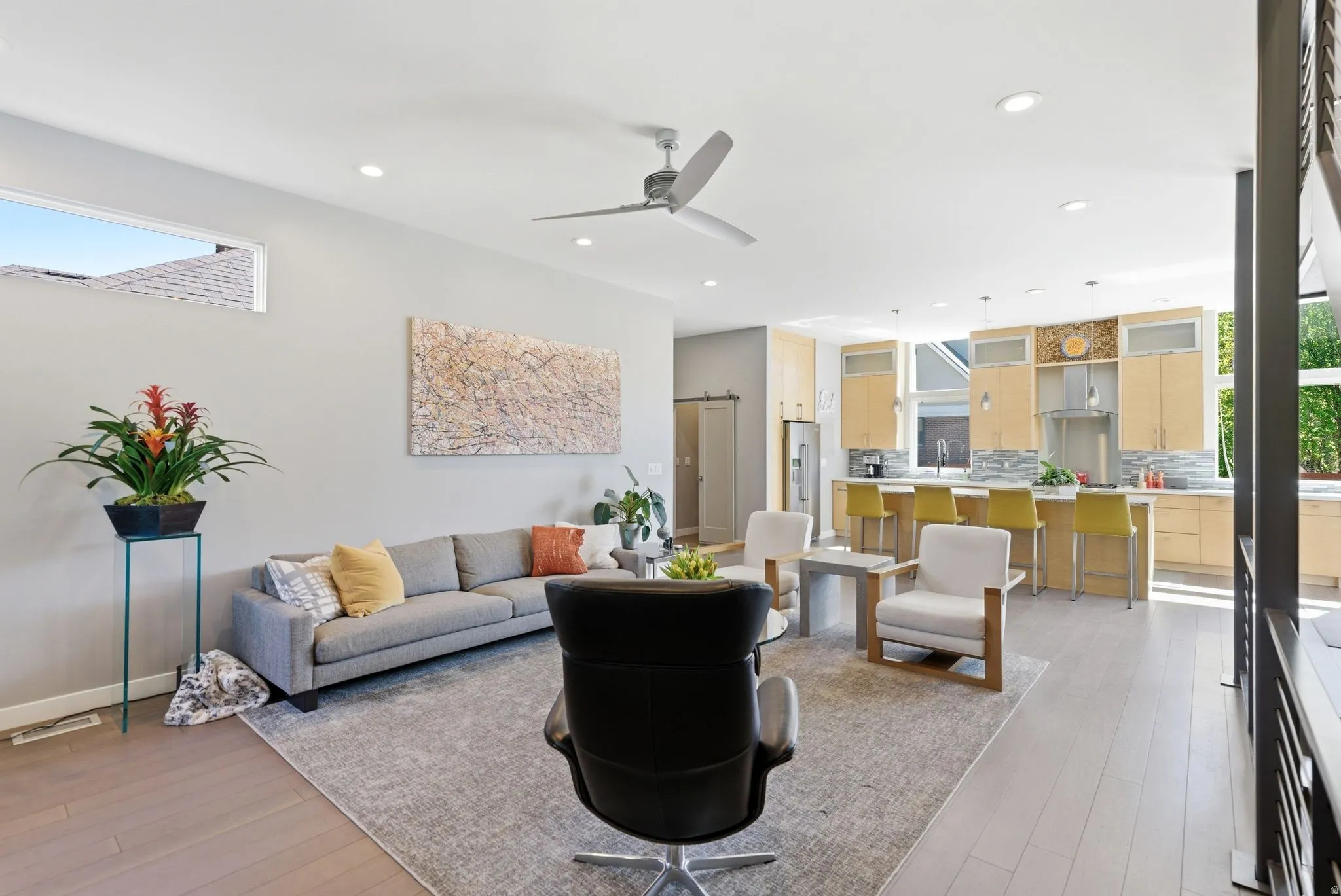 Open-concept living space featuring wood-finish flooring and a contemporary ceiling fan