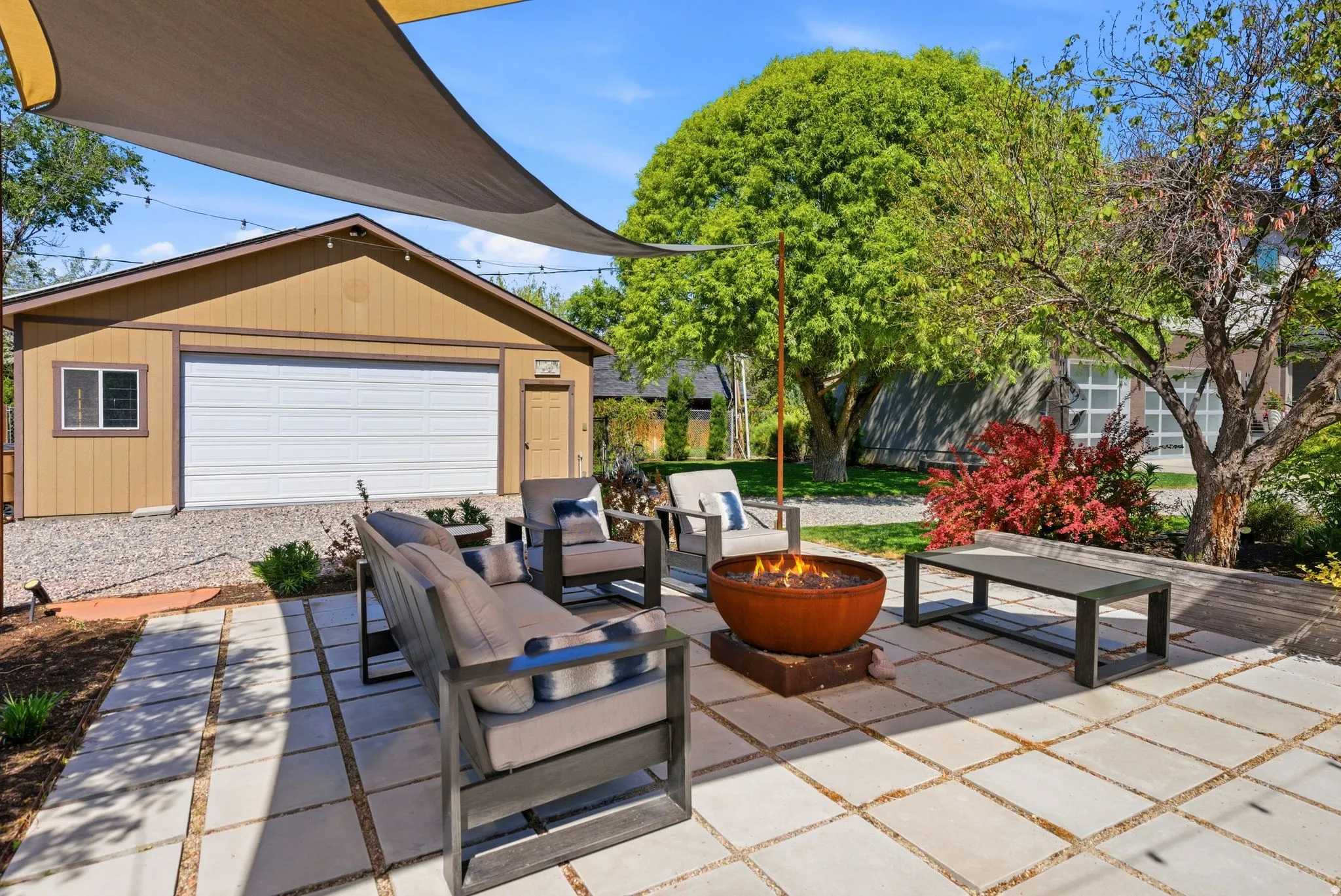 Expansive outdoor patio featuring large square pavers and a built-in fire pit