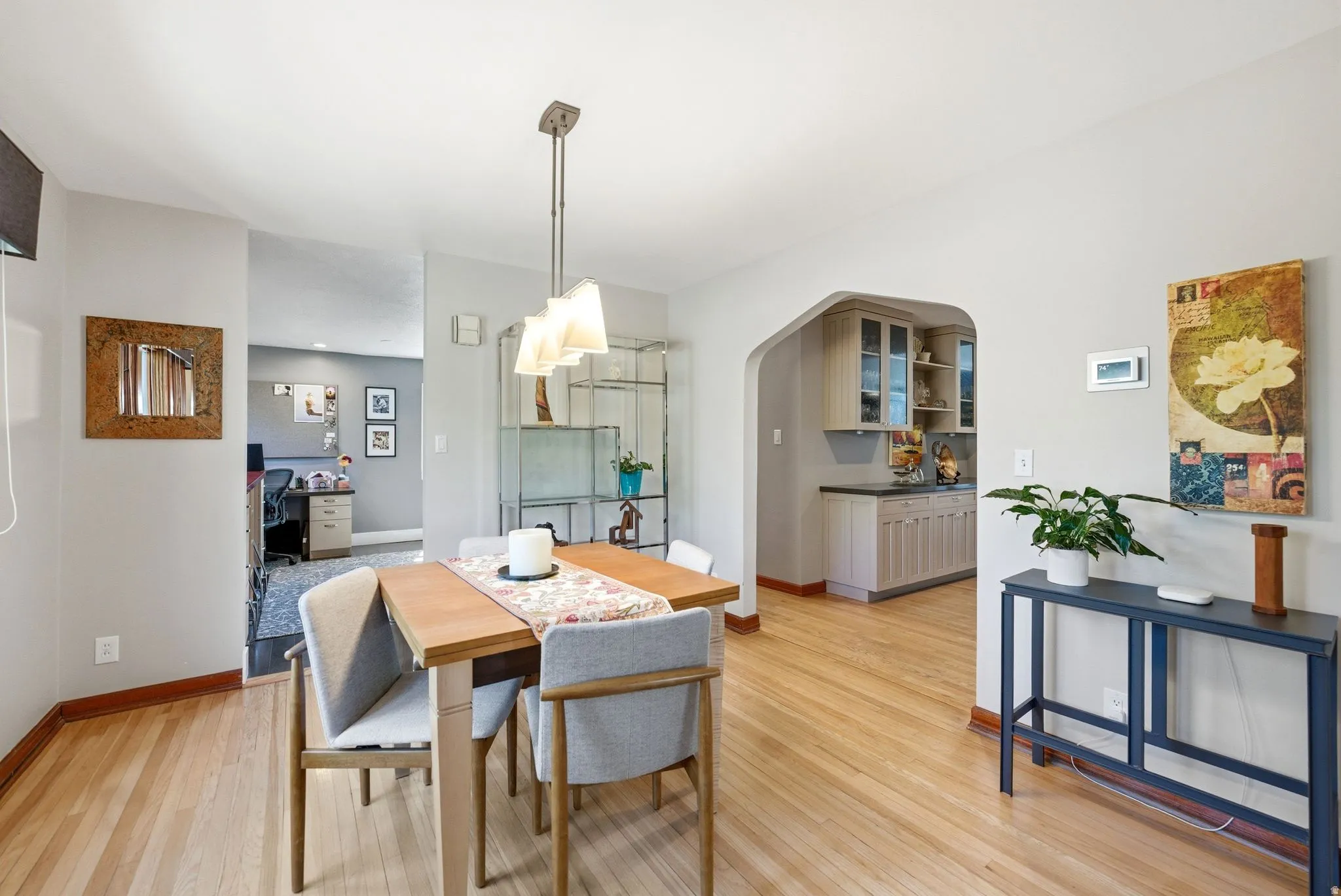 Dining area featuring light wood-finish flooring, a contemporary pendant light fixture, and light gray wall paint