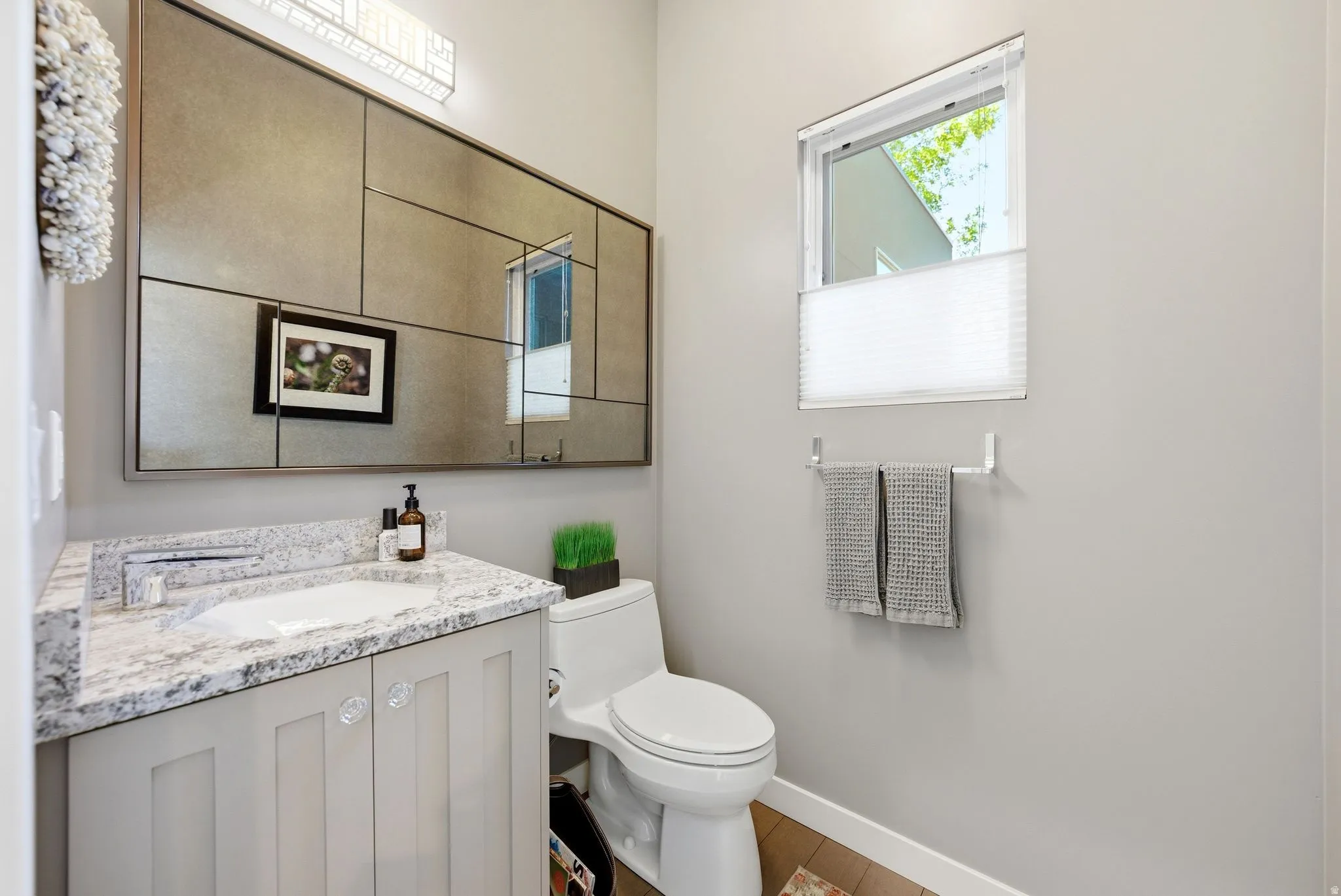 Bathroom featuring a light-toned vanity with a granite countertop and an undermount sink