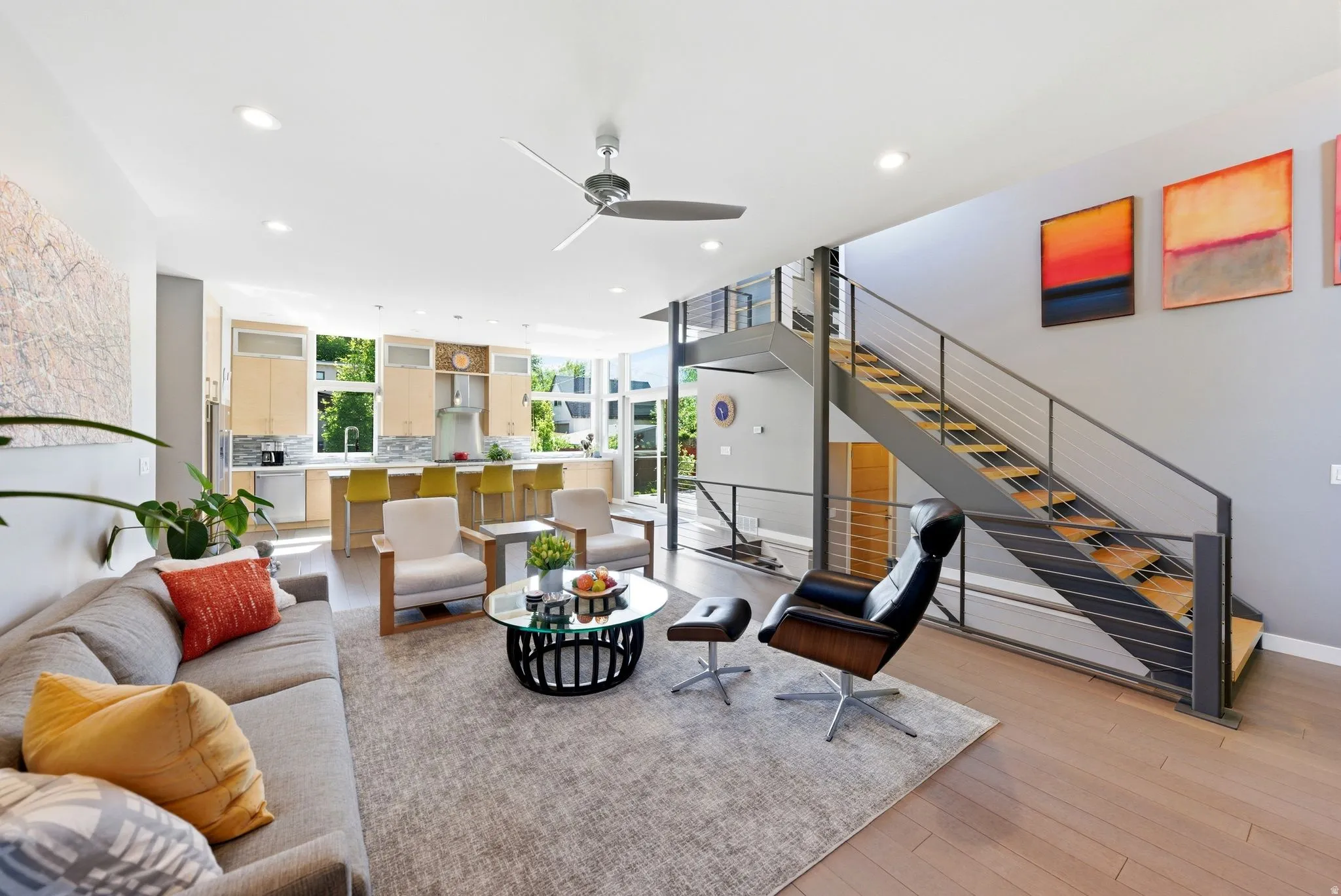Open-concept living space featuring wood-finish flooring, recessed lighting, and a contemporary ceiling fan