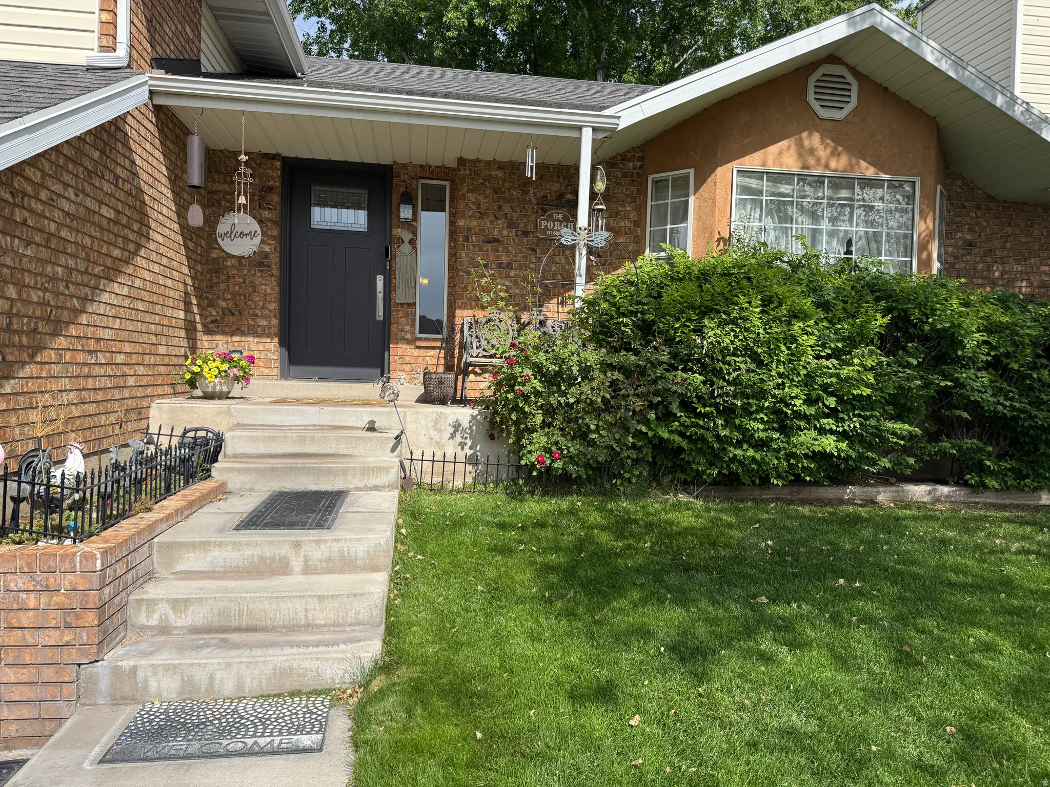 Brick and stucco facade featuring a dark entry door with frosted glass insert