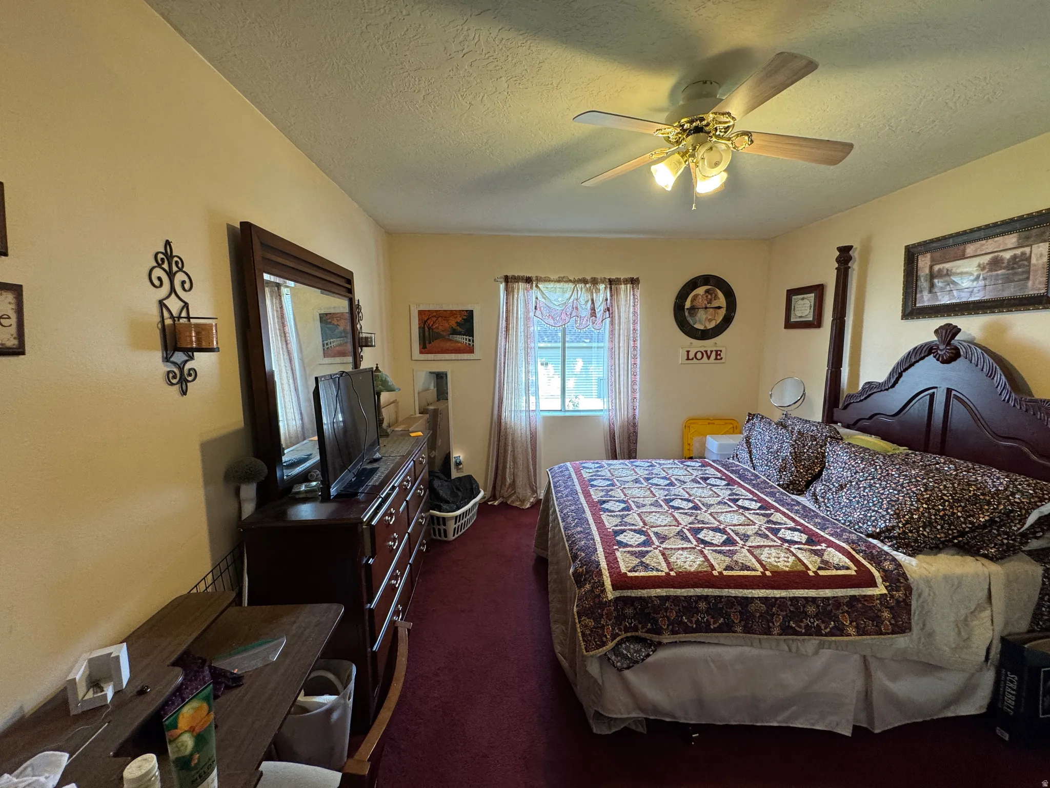 Bedroom featuring warm-toned walls, a ceiling fan with integrated lighting, and a window providing natural illumination