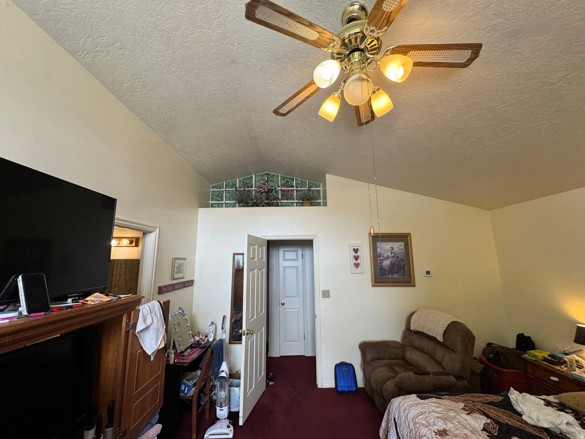 Vaulted ceiling with an overhead ceiling fan and light fixture