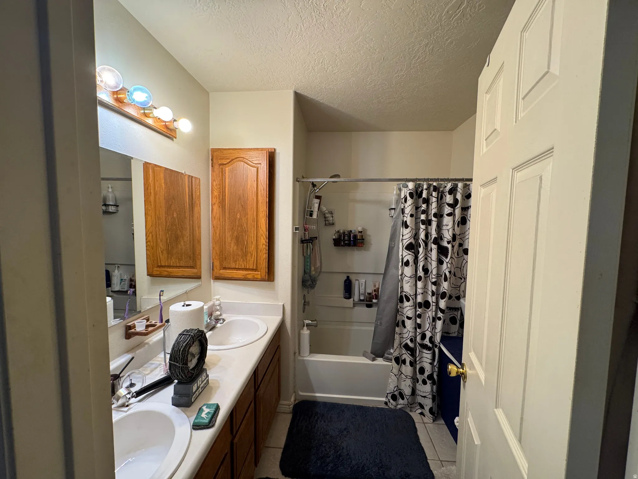 Double vanity with integrated sinks, ample countertop space, and oak cabinetry