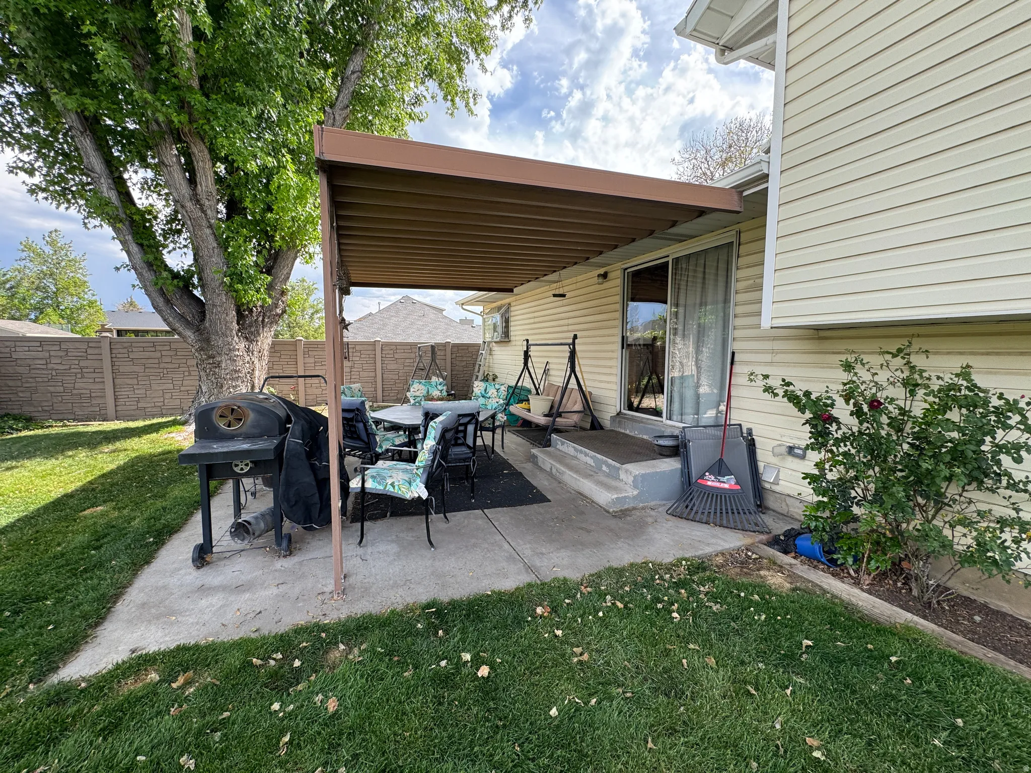 Private patio area featuring a metal pergola, concrete slab, and direct access through a sliding glass door
