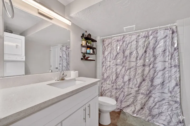 Vanity with a light-toned countertop, integrated sink, and chrome faucet