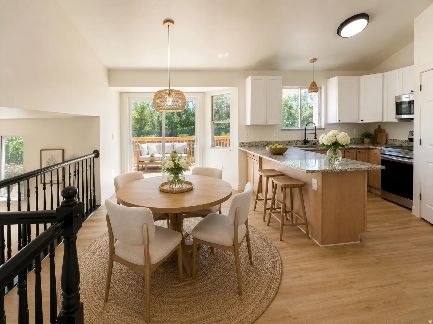 Open-concept kitchen and dining area featuring light wood-finish flooring--virtually staged