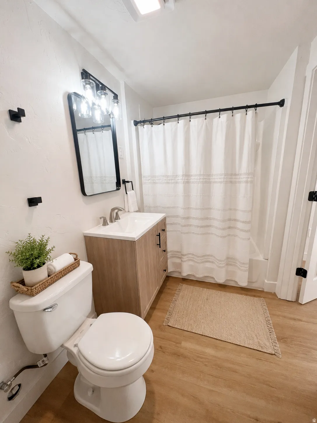 Full bathroom in basement featuring a light wood-finish vanity with a white countertop and integrated sink