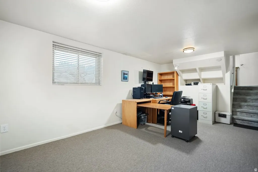 Carpeted room with a window featuring horizontal blinds