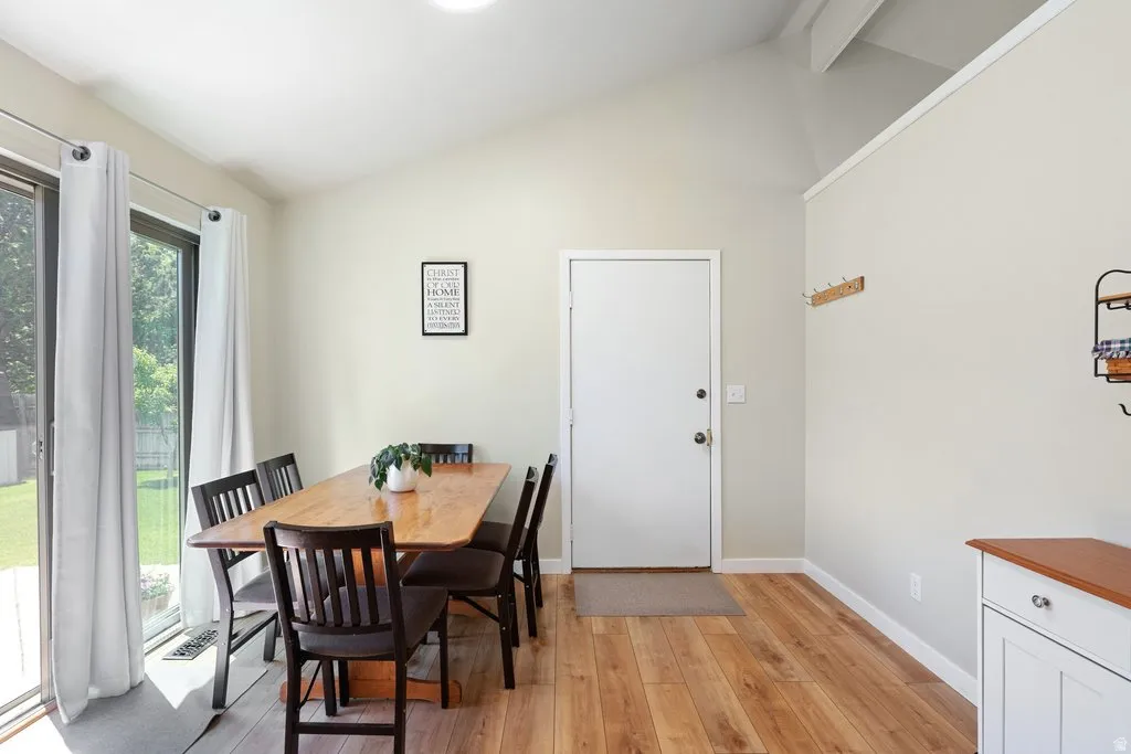 Dining area featuring wood-finish flooring and a vaulted ceiling