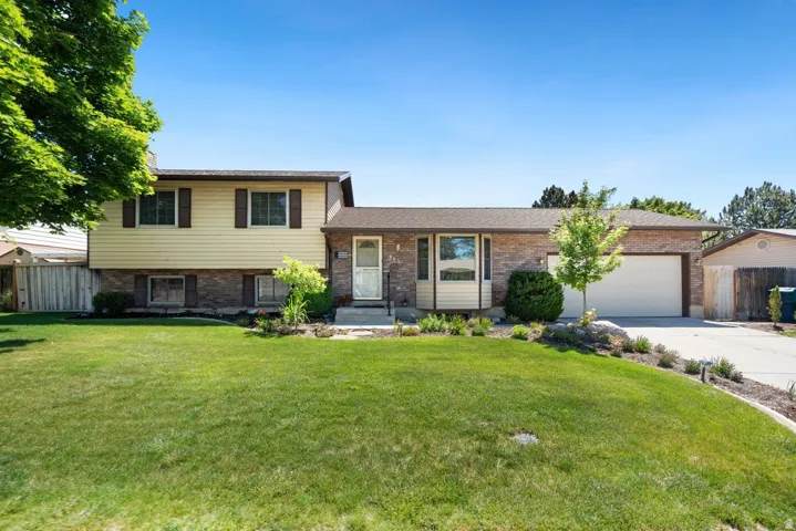 Split-level property featuring a brick and siding exterior, an attached two-car garage, and a concrete driveway