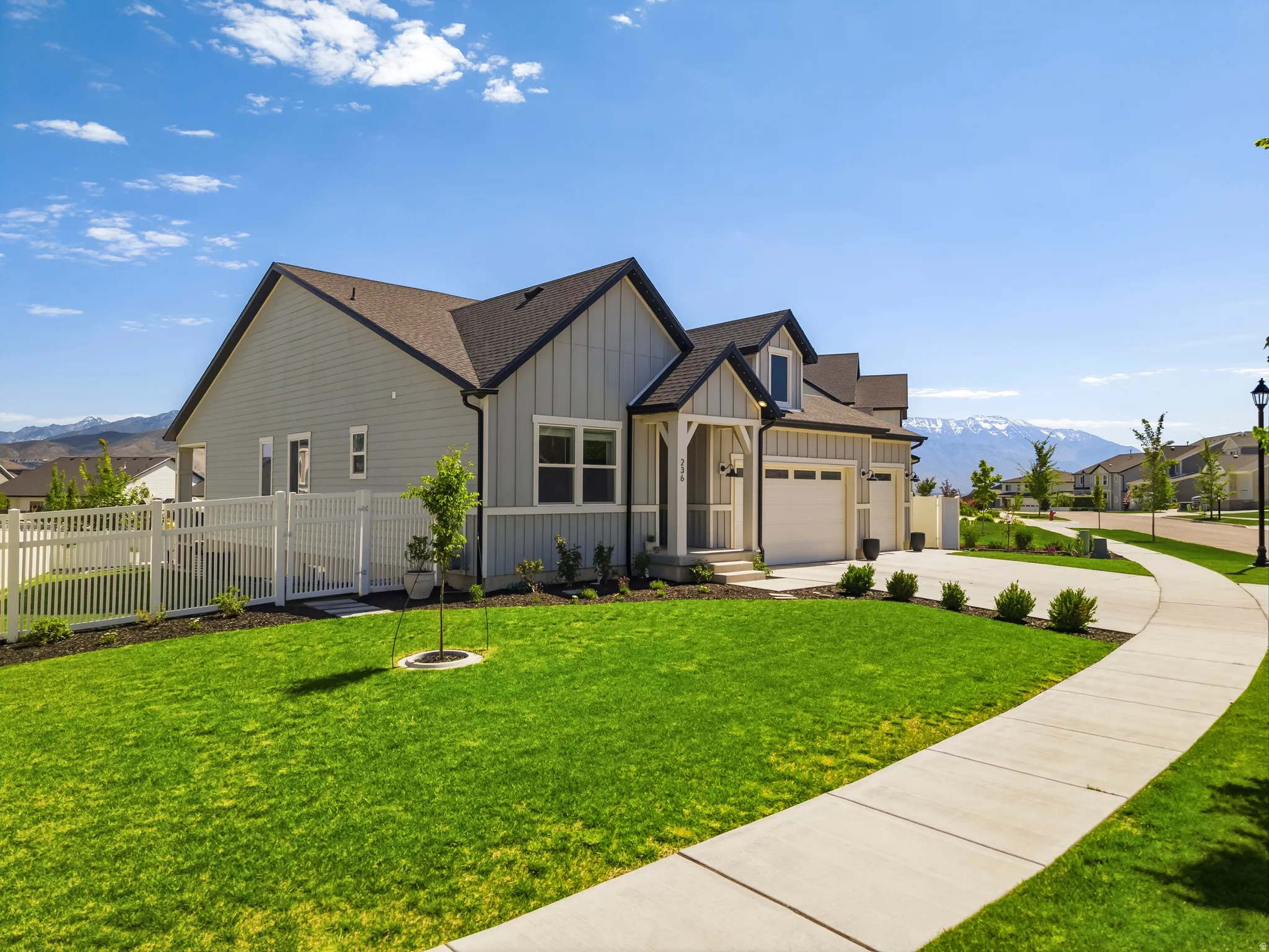 Contemporary home with light gray siding, dark trim, and a prominent front porch